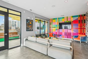 a living room with couches and a television and a colorful wall at Link Apartments® Mint Street, Charlotte, NC, 28203